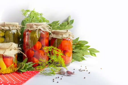Glass jars with homemade pickled tomatoes, sealed with metal lidの写真素材