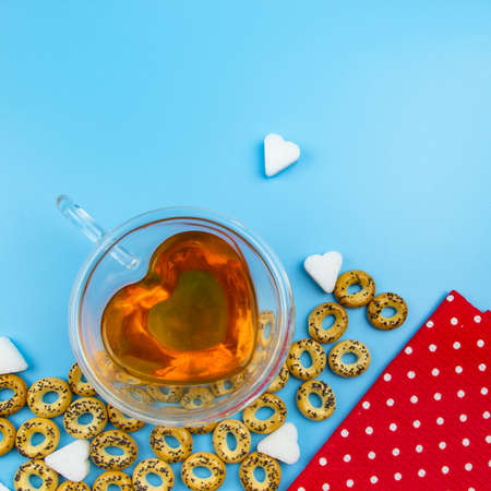 Tea in a transparent cup and drying bagels. Sugar lumps and a sprig of mint. Background for the...