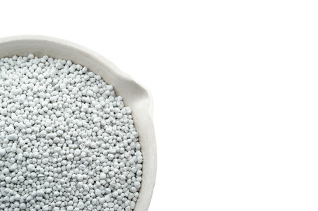 Mineral fertilizers in a chemical porcelain cup, isolated on the white backgroundの写真素材