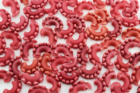 Dry colored italian pasta closeup on white backgroundの写真素材