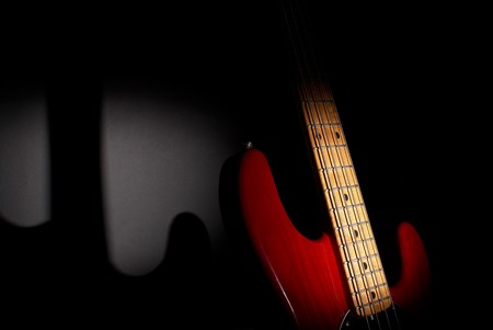 Wooden four string fretted  electric bass instrument