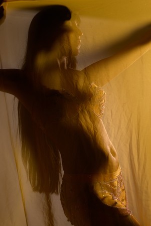 Oriental dancer with sensual movement behind a translucent headscarfの写真素材