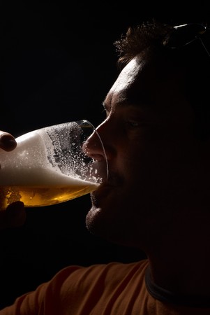 Silhouette portrait of a man enjoying a pint of beerの写真素材