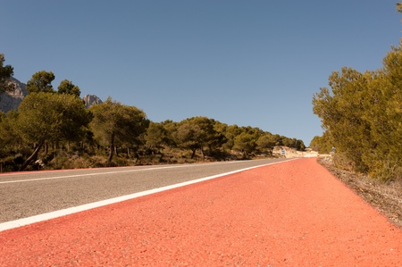 Scenic countryside road with a red bicycle laneの写真素材
