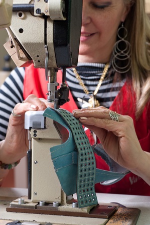 Female worker sewing leather in a footwear factoryの写真素材