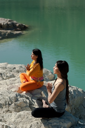 MOther and daughter, yoga at beautiful lakeside settingの写真素材