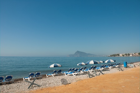 Sunshades and deckchairs on a quiet beachの写真素材