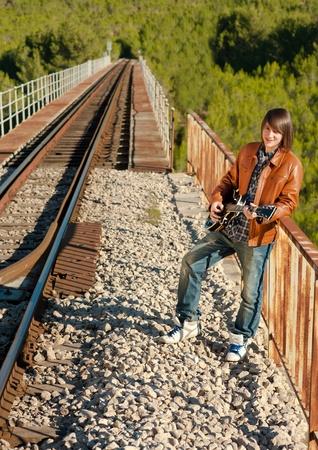 Guitarist performing on a railway bridgeの写真素材