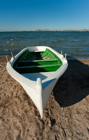 White fishing boat resting on a Mediterranean beachの写真素材