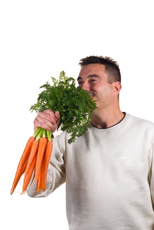 Guy happily holding a bunch of carrots, dieting conceptの写真素材