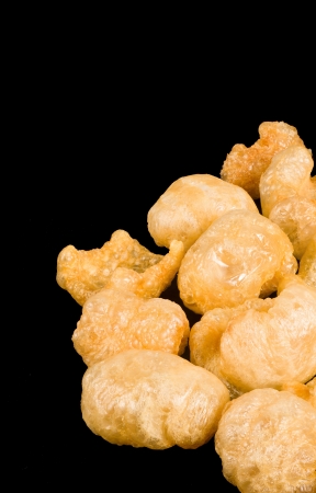 Deep fried pork rind snack isolated on blackの写真素材
