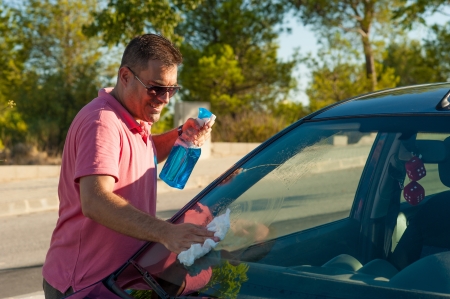 Hispanic male cleaning his car windscreenの写真素材
