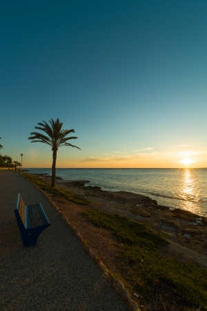 Sunrise on the calm scenics of a Mediterranean beach promenadeの写真素材