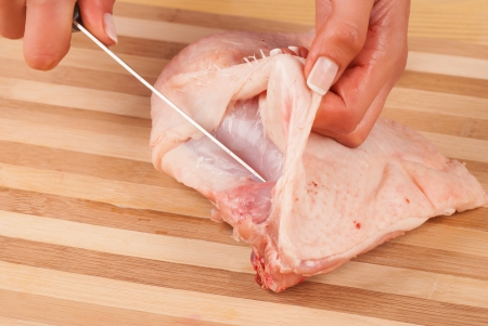 Hands preparing a piece of fresh  chickenの写真素材