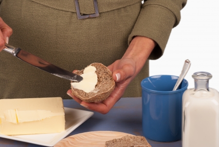 Spreading fresh butter on a whole wheat bun