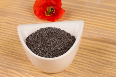 Poppy seeds with the flower in the backgroundの写真素材