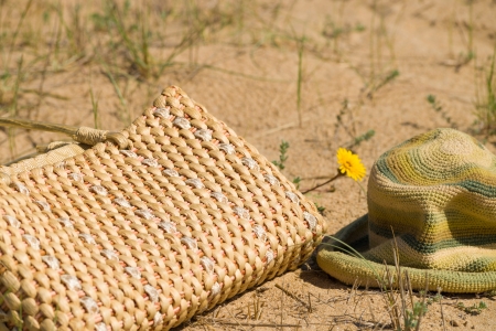 Handbag and cap on a sunny dune in  springの写真素材