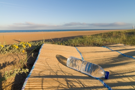 A bottle of fresh mineral water on a beach mat, a summertime conceptの写真素材
