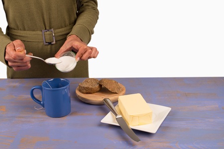 Adding sugar to a mug of tea at breakfast timeの写真素材