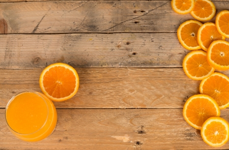 Background with fresh oranges and juice on a wooden tableの写真素材