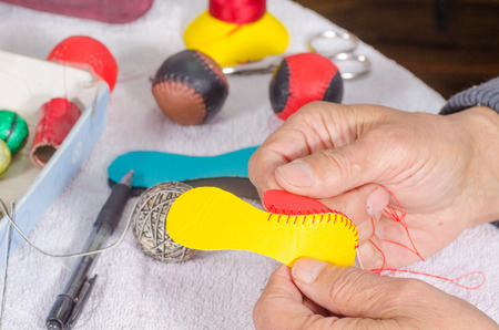  Leather craft, male hands sewing  traditional sport balls