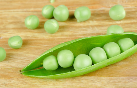 An open bud with fresh peas on a wooden backgroundの写真素材