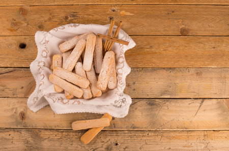 A basket full of ladyfinger biscuits on a rustic table
