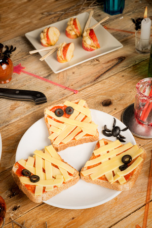 Spooky Halloween snacks set up on a wooden tableの写真素材