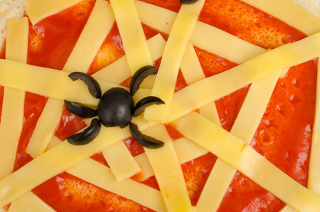 Closeup take of a tomato and cheese cobweb, a Halloween pizzaの写真素材