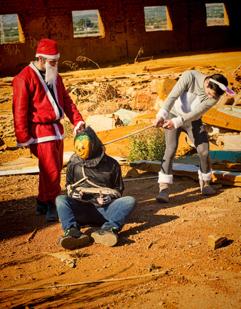 Halloween monster being taken prisoner by Santa and the Easter bunnyの写真素材