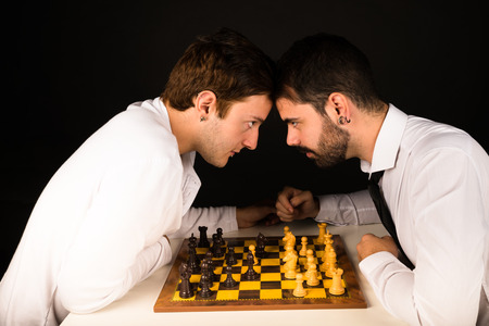 Two guys in their 20s clashing over a chess boardの写真素材