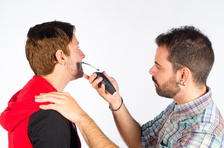 Barber trimming a beard with an electric razorの写真素材