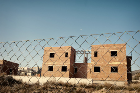 Fenced building site with abandoned unfinished housesの写真素材