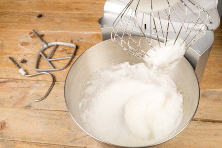 Freashly beaten stiff egg white inside a food processorの写真素材