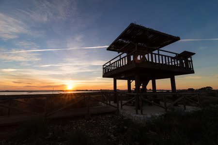 Wooden wildlife observation watchtower against the background of a sunriseの写真素材
