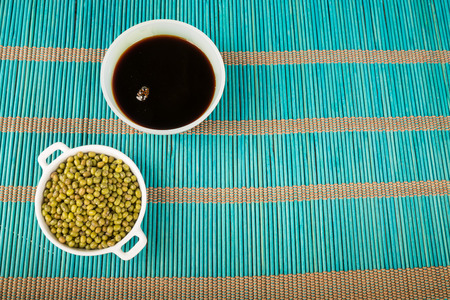 Soy sauce and soy beans on a bamboo matの写真素材