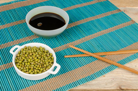 Soy sauce and soy beans on a bamboo matの写真素材