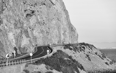 Black and white take of a road winding along cliffsの写真素材