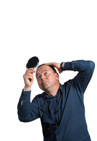 Worried guy having a closer look at his balding headの写真素材