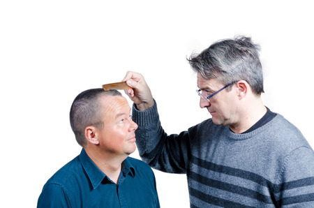 Guy making fun of his friends hair lossの写真素材