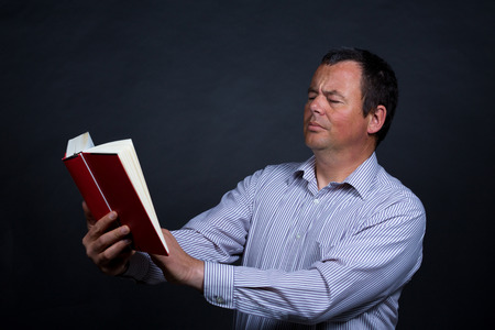Man finding it increasingly difficult to read without glassesの写真素材