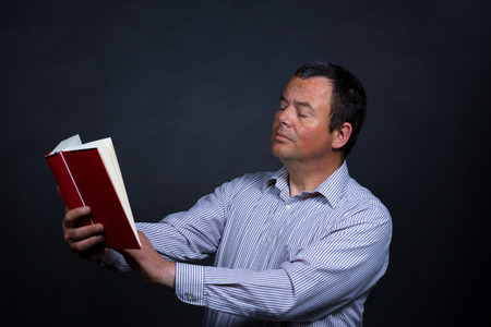 Man finding it increasingly difficult to read without glassesの写真素材