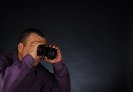 Man watching out through photography lenses, a conceptの写真素材