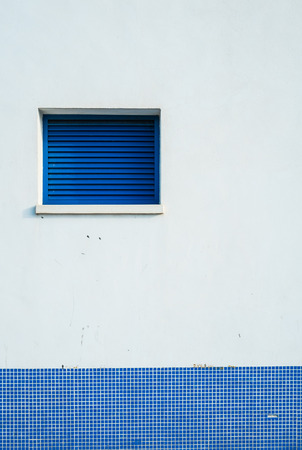 Blue window on a blue and white wallの写真素材