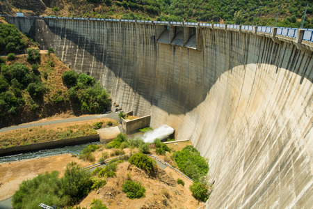 Large concrete reservoir dam  surrounded by forestの写真素材