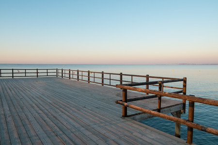 Wooden jetty leading into sunny Mediterranean watersの写真素材