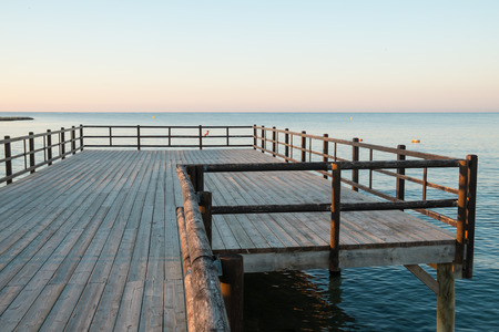 Wooden jetty leading into sunny Mediterranean waters