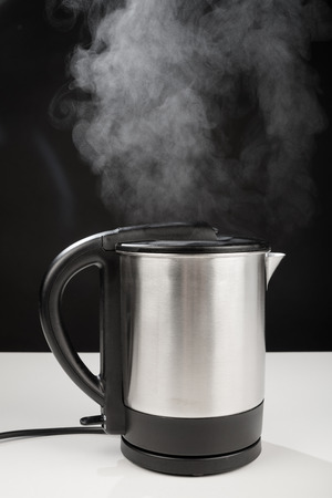 Hot boiling kettle letting out some steamの写真素材