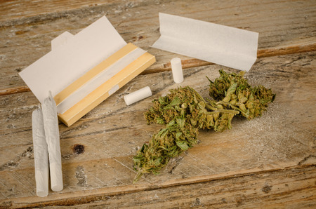 Ingredients to roll a joint on a rustic wooden tableの写真素材