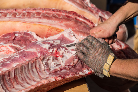 Butcher preparing pork  outdoors during a traditional festival